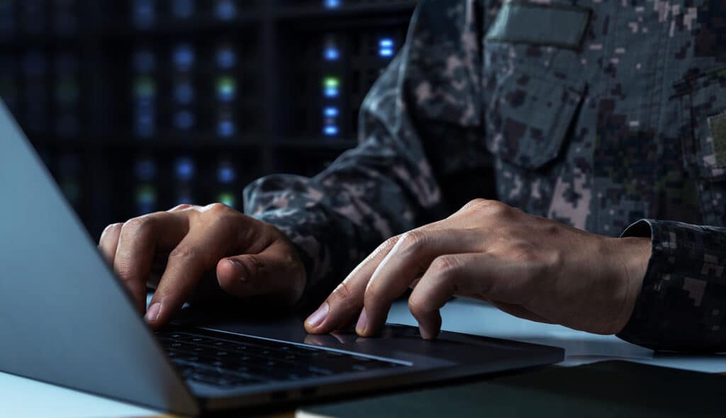 Information Technology Support | Military Man using laptop inside military server room | Saalex Solutions